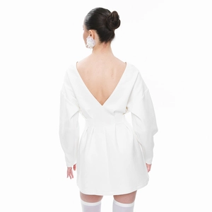 Detail of white long sleeve dress featuring deep V back and pleated waist design