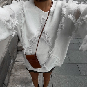 Detail of white long sleeve knit sweater featuring unique distressed fringe and frayed texture