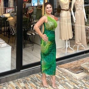 Dettaglio di un elegante abito midi monospalla con stampa marmo verde e linea slim