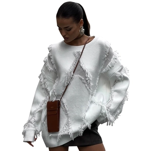 Detail of white loose knit sweater featuring unique diagonal fringe and distressed hem