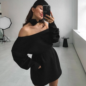 Detail of a black long-sleeve mini dress with an elegant off-shoulder neck and slim fit waist