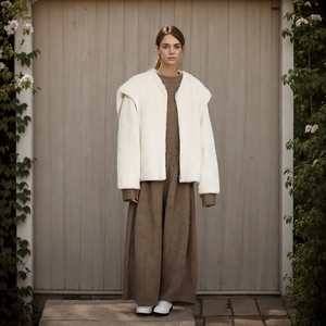Close-up of white fleece jacket texture and brown ribbed knit dress material detail