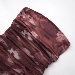 Detalle de la tela fruncida con flores rojas de un minivestido palabra de honor