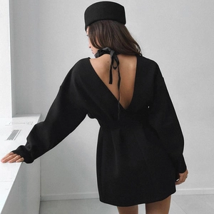 Detail view of long-sleeve black dress featuring a deep V-back with elegant ribbon tie