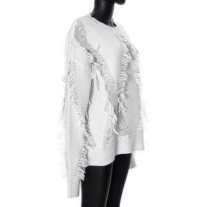 Detailed texture of white knit sweater featuring distressed fringe and frayed trim accents