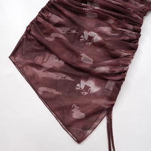Detalle de vestido de malla burdeos con estampado floral y diseño de cordón fruncido