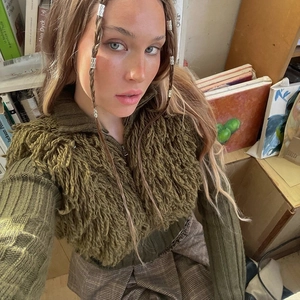Detailed texture of olive green shaggy knit cardigan with front zipper and ribbed sleeves