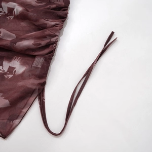 Detalle del vestido de malla burdeos con fruncido lateral y estampado floral