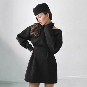 Detail of minimalist black long sleeve dress with waist slimming cut and matching hat