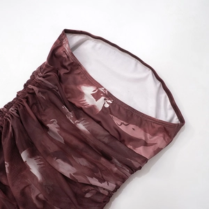 Detalle de tela floral rojo oscuro fruncida con textura elástica y costura de calidad