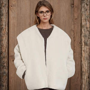 Detail of creamy white faux fur jacket featuring a large collar and zipper closure