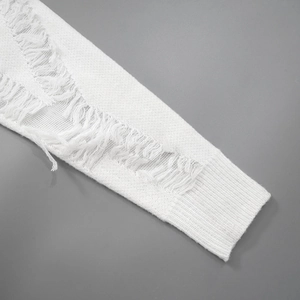 Detail of white knit sleeve featuring distressed ripped holes and ribbed cuff texture
