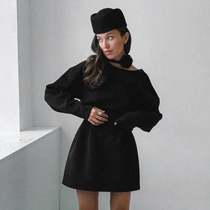 Detail of long sleeve black mini dress with boat neck and high waist silhouette