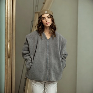 Detail of grey sherpa fleece jacket texture with zipper closure and soft plush material
