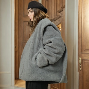 Detail of grey oversized sherpa fleece jacket with a textured wool-like grain and side pocket