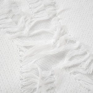 Macro detail of white knit sweater with distressed frayed edges and texture