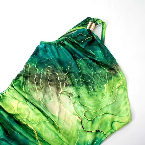 Dettaglio di un abito elegante con stampa marmo verde e raffinata fibbia in metallo oro