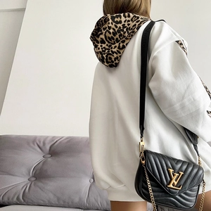 Close-up of leopard print hood and striped patchwork details on white casual hoodie