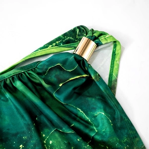 Dettaglio dell'abito con stampa marmo verde e un elegante anello in metallo dorato sulla spalla