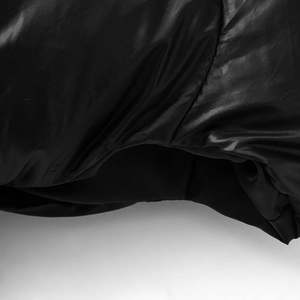 Gros plan sur le tissu noir brillant coupe-vent et les coutures de précision de la veste