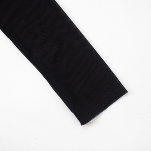 Close-up detail of sheer black mesh fabric on long sleeve dress showing fine texture