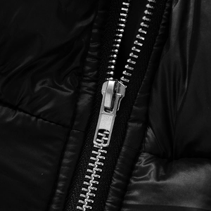 Macro du tissu brillant et du zip en métal argenté sur une veste courte matelassée noire