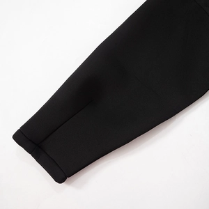 Close-up of the black dress sleeve showing high-quality stitching and dense fabric texture