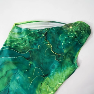 Primo piano del motivo marmorizzato verde e oro su tessuto elastico di alta qualità