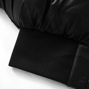 Détail de la veste rembourrée noire brillante avec poignets en tricot côtelé élastique