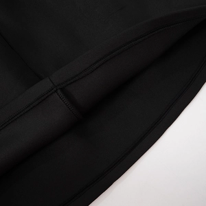 Detail of premium double-stitched hem on the black long sleeve minimalist dress