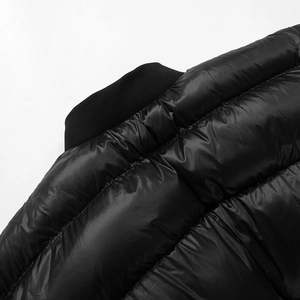 Détail d'une veste matelassée noire avec col en maille côtelée et tissu brillant