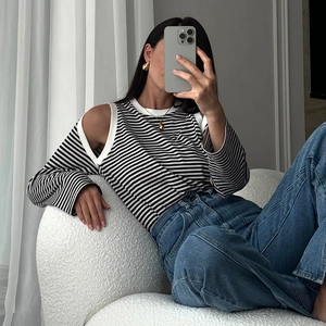 Detail of striped long sleeve knit top with shoulder cut-out and ribbed white crew neck