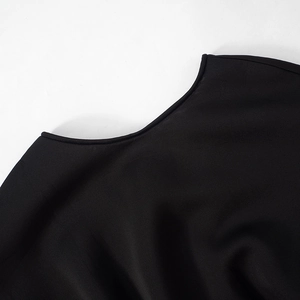 Detailed view of the ribbed crew neckline and high-quality stitching on a black mini dress
