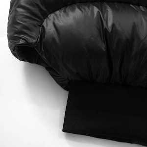 Détail du tissu matelassé noir brillant avec poignets en tricot côtelé et finitions
