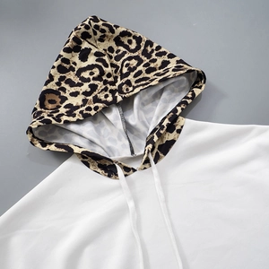 Detail of white hoodie featuring a leopard print hood and thick woven drawstrings