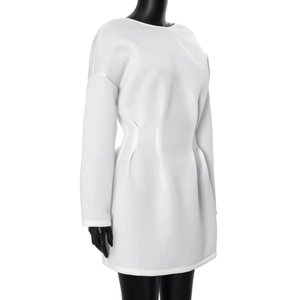 Detail of white long sleeve mini dress featuring structured waist pleats and soft fabric