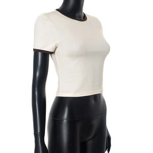 Detail eines cremefarbenen Cropped-T-Shirts mit braunem Kontrastsaum an Kragen und Ärmeln
