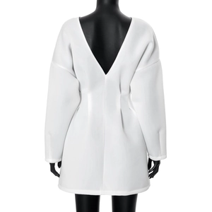 Detail view of white long sleeve dress showing backless V-neck and pleated waist