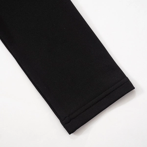 Détail de la manche d'une robe noire en tricot dense avec couture double précise