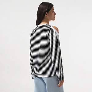 Detail view of striped long sleeve top featuring a cutout cold shoulder and white piping