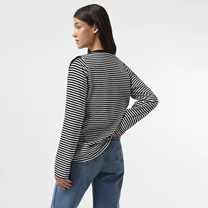 Side-back view of black and white striped long sleeve top with a classic crew neck