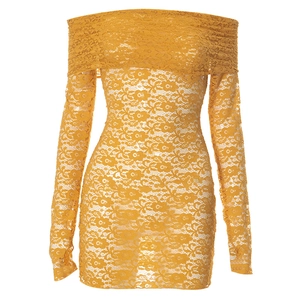Détail de la dentelle jaune gingembre avec broderies florales sur la robe à épaules dénudées