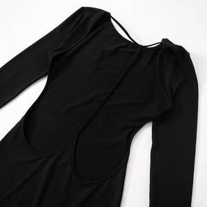 Détail à plat de la robe noire à manches longues avec un design sexy dos nu à brides en T