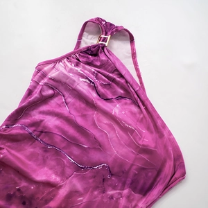 Dettaglio del tessuto con motivo a marmo viola e fibbia in metallo dorato lucido ed elegante
