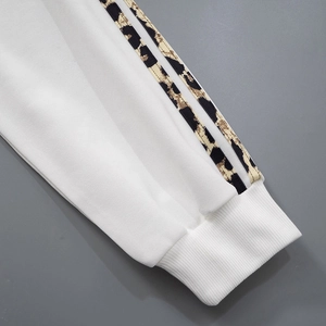 Close-up of white ribbed cuffs featuring stylish leopard print side stripes detail