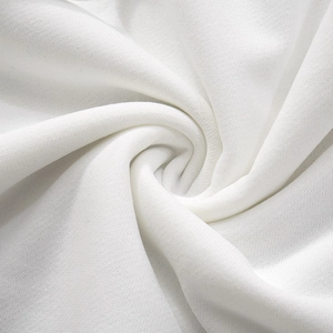 Close-up of white knit cotton fabric texture with soft spiral folds and fine fiber details