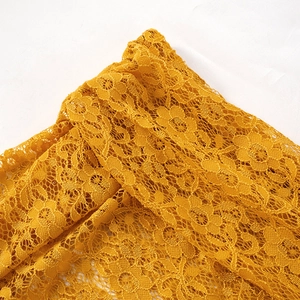 Vue détaillée de la dentelle florale jaune aux motifs ajourés sophistiqués