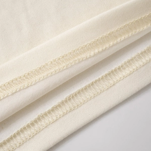 Detaillierte Nahaufnahme der hochwertigen Overlock-Naht an beigen Strickstoffkanten