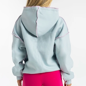 Close-up of light blue oversized hoodie with purple reverse seam and hooded structure