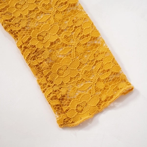 Gros plan détaillé sur la texture de la dentelle évidée de la manche d'une robe jaune